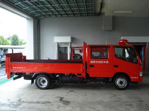 赤色のトラック型の消防車で白い文字で「秦野市消防本部」と書かれた運搬用の消防車で、荷台には器材などを積み込めるようになっている災害対応搬送車の写真