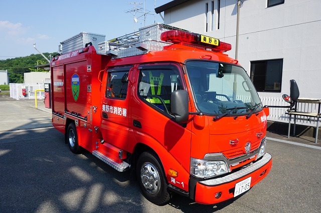 鮮やかな赤色の中型消防ポンプ車が屋外に停車しており、車体側面には白文字で「秦野市消防署」と書かれ、上部には赤色灯、屋根には銀色のホース収納箱が搭載されている消防署南分署の消防ポンプ自動車の写真