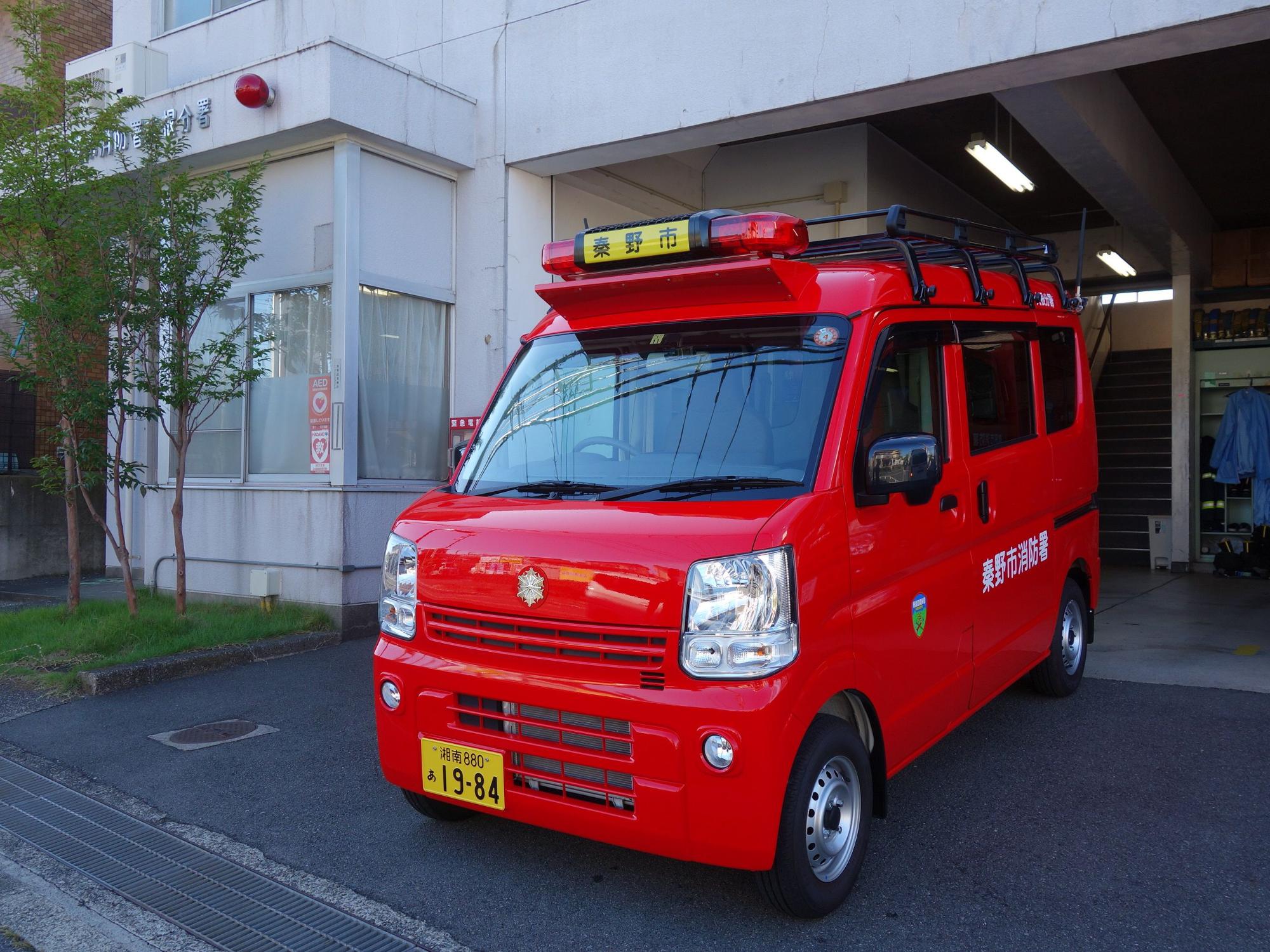 小型の赤いバンタイプの車両で、「秦野市消防署」と白文字で書かれており、屋根には赤色灯と黒いキャリアが設置されている消防署大根分署の災害対応搬送車の写真