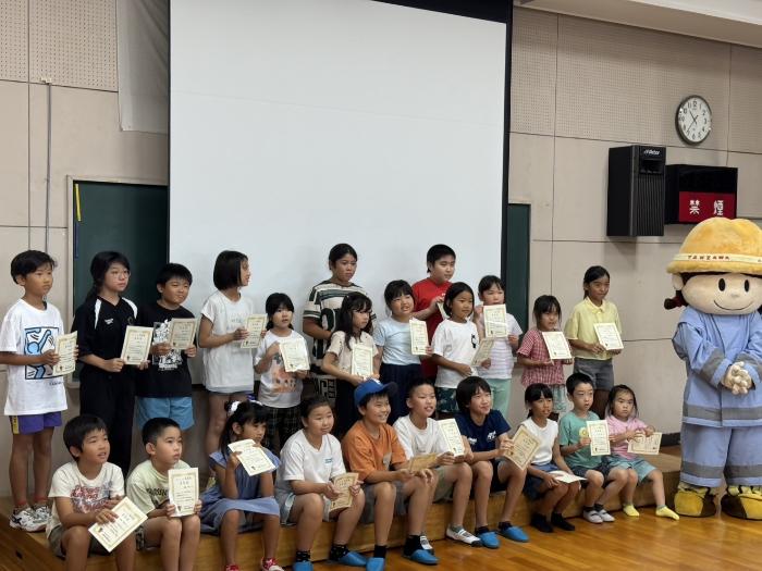 子供たちが任命証を手に笑顔で記念撮影している