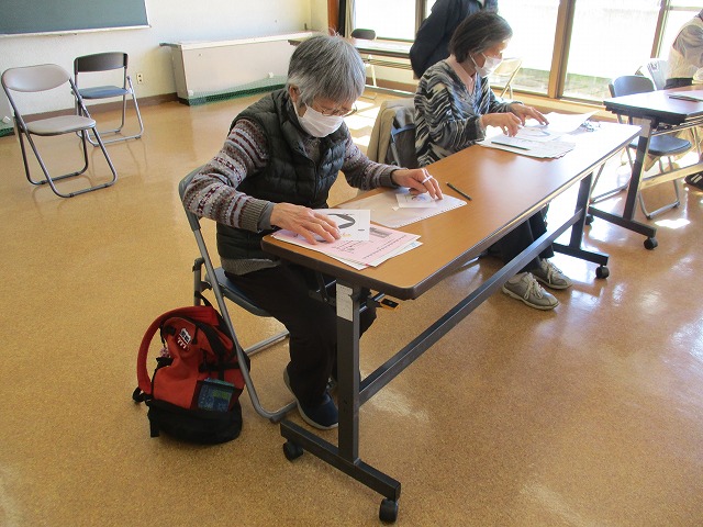 長テーブルに座った二人の女性が、資料を広げて読んでいる、健康講座に参加している写真