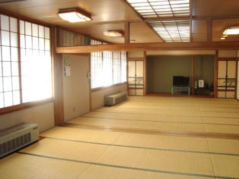 2間続きで障子窓があり、奥にテレビが設置された和室の写真