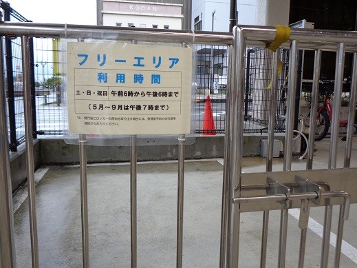ステンレス製の柵に取り付けられた「フリーエリア 利用時間」の案内看板のクローズアップ写真