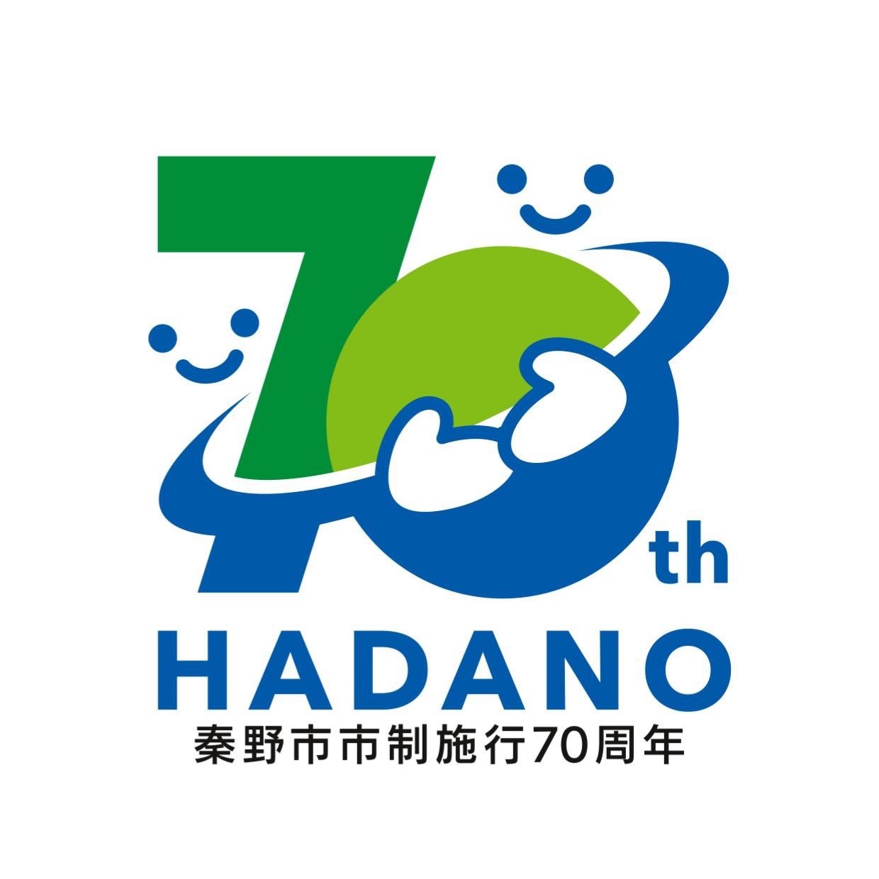 下部に黒文字で「秦野市市制施行70周年」と記載され、青色と緑色を基調としたデザインで、笑顔のキャラクターが「70」という数字と「HADANO」の文字を抱えるように配置されたロゴマークのイラスト