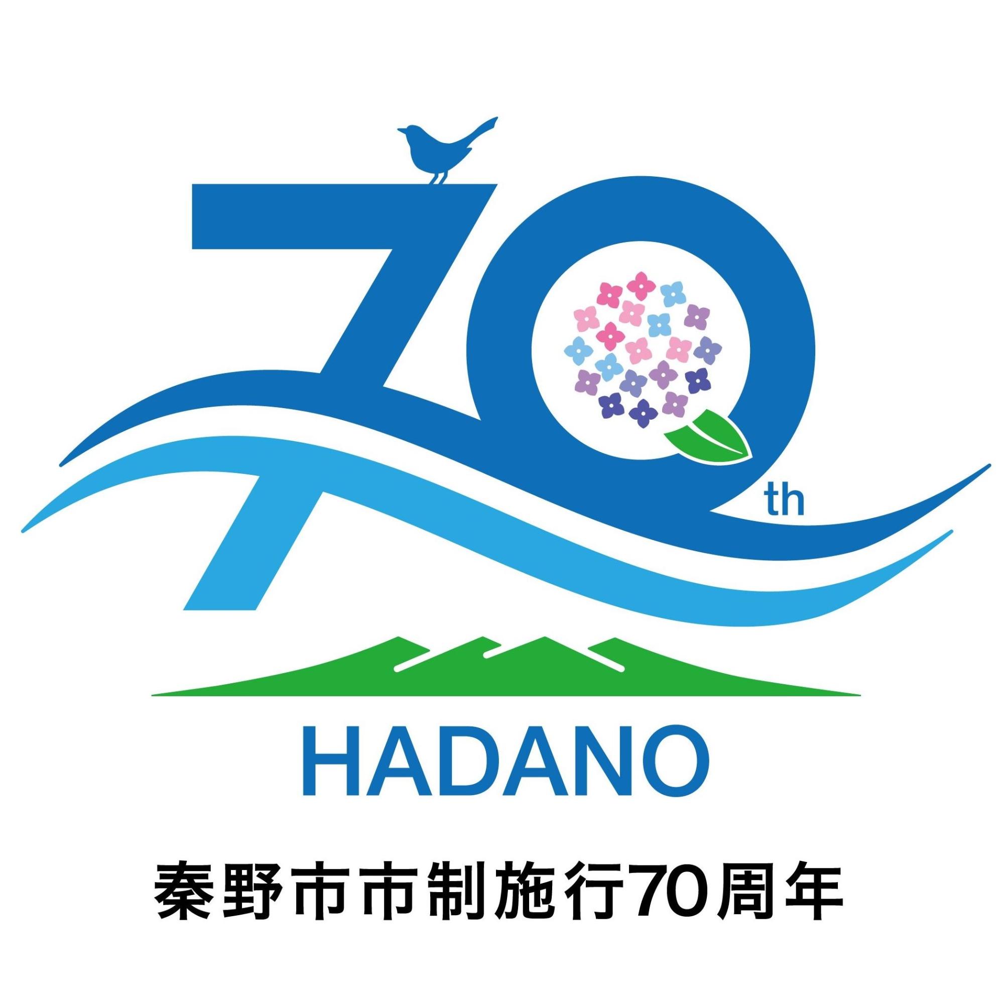 「秦野市市制施行70周年」という文字が下部に配置され、緑色で丹沢連峰がデザインされている上に、大きな「70th」という数字と、その上に市鳥のうぐいすが止まっているデザインが特徴的なロゴマークのイラスト