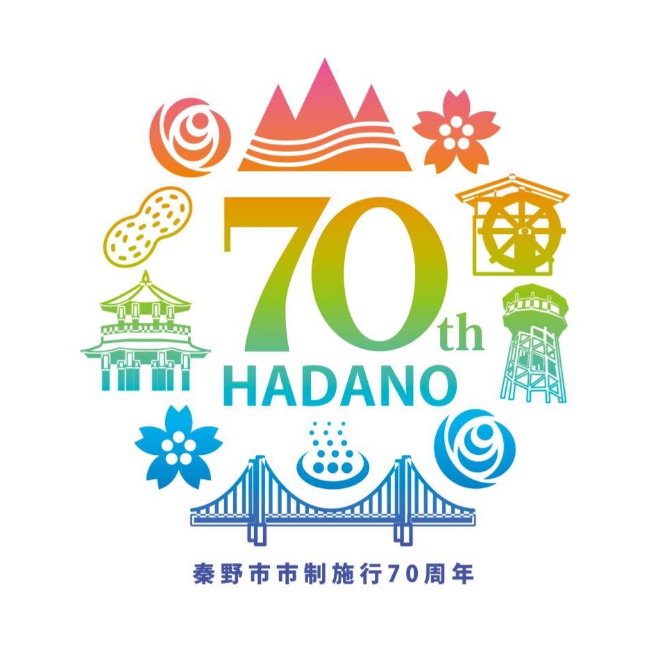 下部に「秦野市市制施行70周年」という文字が青色で配置され、中央には大きく「70th HADANO」という文字が書かれ、周りを複数の秦野市の名所がイラストで配置されている、市の市制施行70周年を記念するロゴマークのイラスト