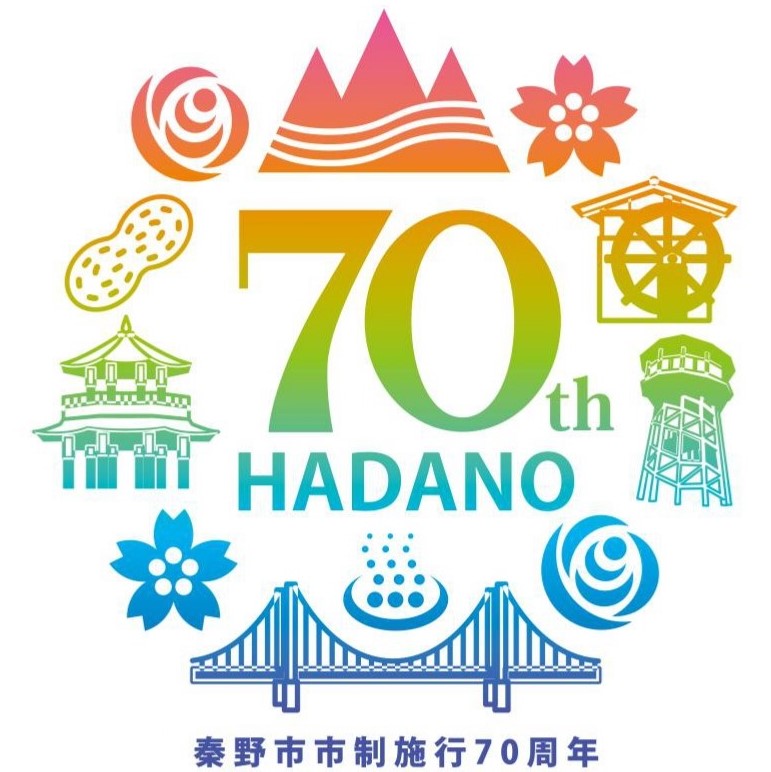 「70th HADANO」という文字が中央に大きく配置され、その周りを落花生、山々、桜、五重塔、水車、貯水塔、水滴、橋などの秦野市を象徴するカラフルなアイコンで囲んだ、秦野市制施行70周年を記念するロゴマーク