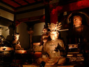 薄暗い室内に複数の仏像が並んで安置され、照明で照らされている大日堂内部の写真