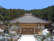 森を背後に建つ立派な造りの金剛寺と、その手前の石庭の中央を通る参道を写した写真