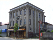 モダンな洋風建築の三階建ての建物が、街灯や消火栓と共に写し出された、五十嵐商店の外観写真