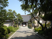 手入れされた植栽が両側にある参道の奥にグレーの瓦屋根の社殿が見える喜叟寺の外観写真