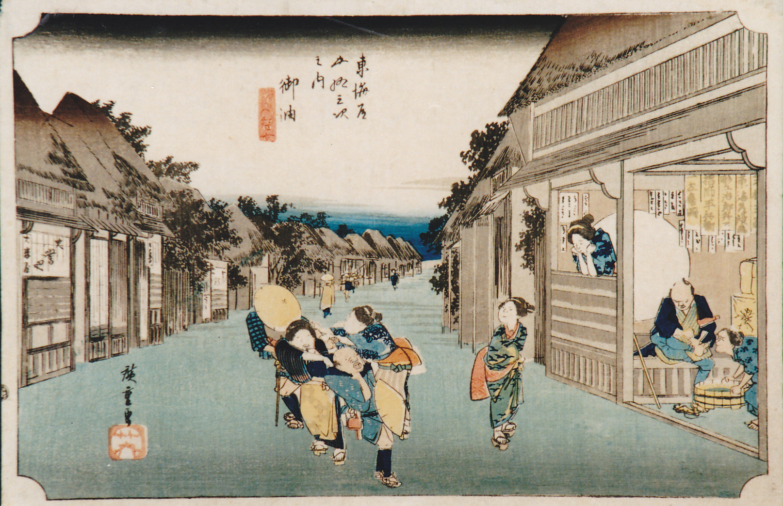 宿場町の賑やかな通りの、団扇売りや旅人、店から身を乗り出す女性などの様子が描かれており、画面上部には文字と署名が記されている浮世絵の画像