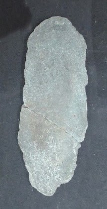 楕円形の板状になっている、薄いグレーの板碑の写真