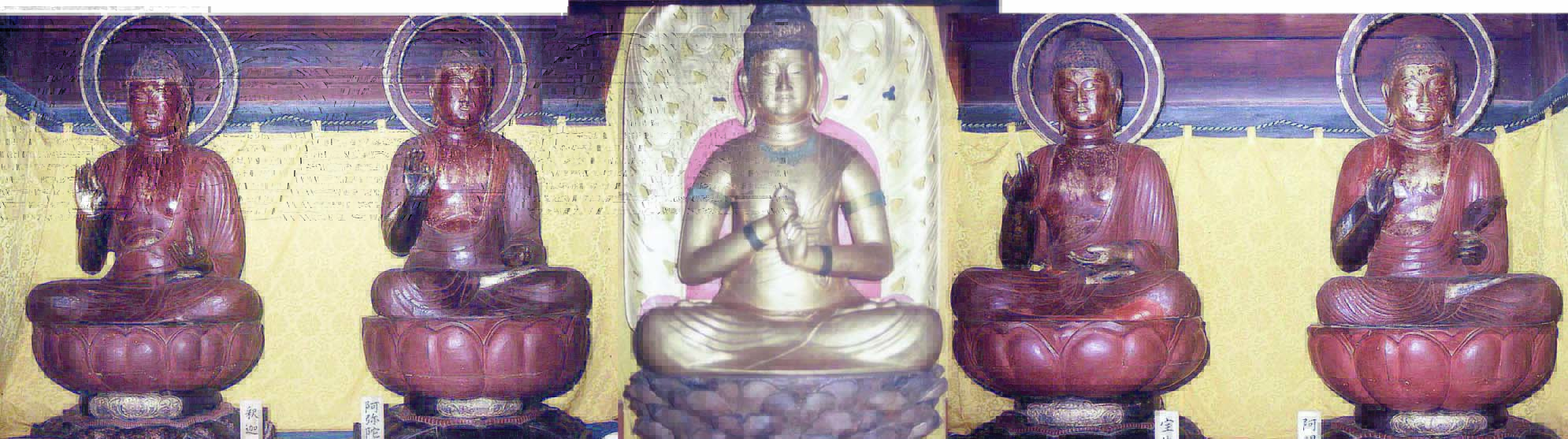 金色の布を背景に安置された金色の座像の左右に、それぞれ二体ずつ赤茶色の座像が並んでいる写真