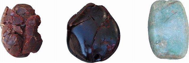 左から赤茶色で表面が割れている琥珀大珠、濃い茶色で光沢のある琥珀大珠、淡い緑色の翡翠大珠が3つ並んだ写真