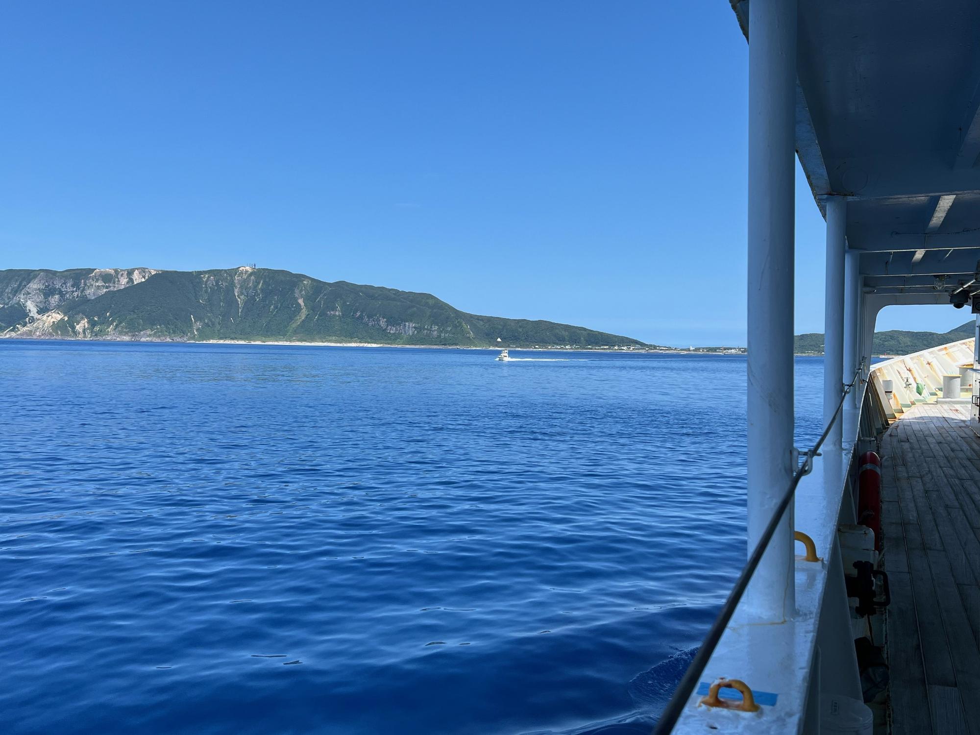 青く澄んだ海と新島を望星丸のデッキの側面から撮影した写真