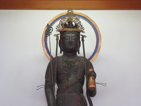 繊細な装飾の施された冠をかぶり、光背を背にした仏像の上半身が写された写真