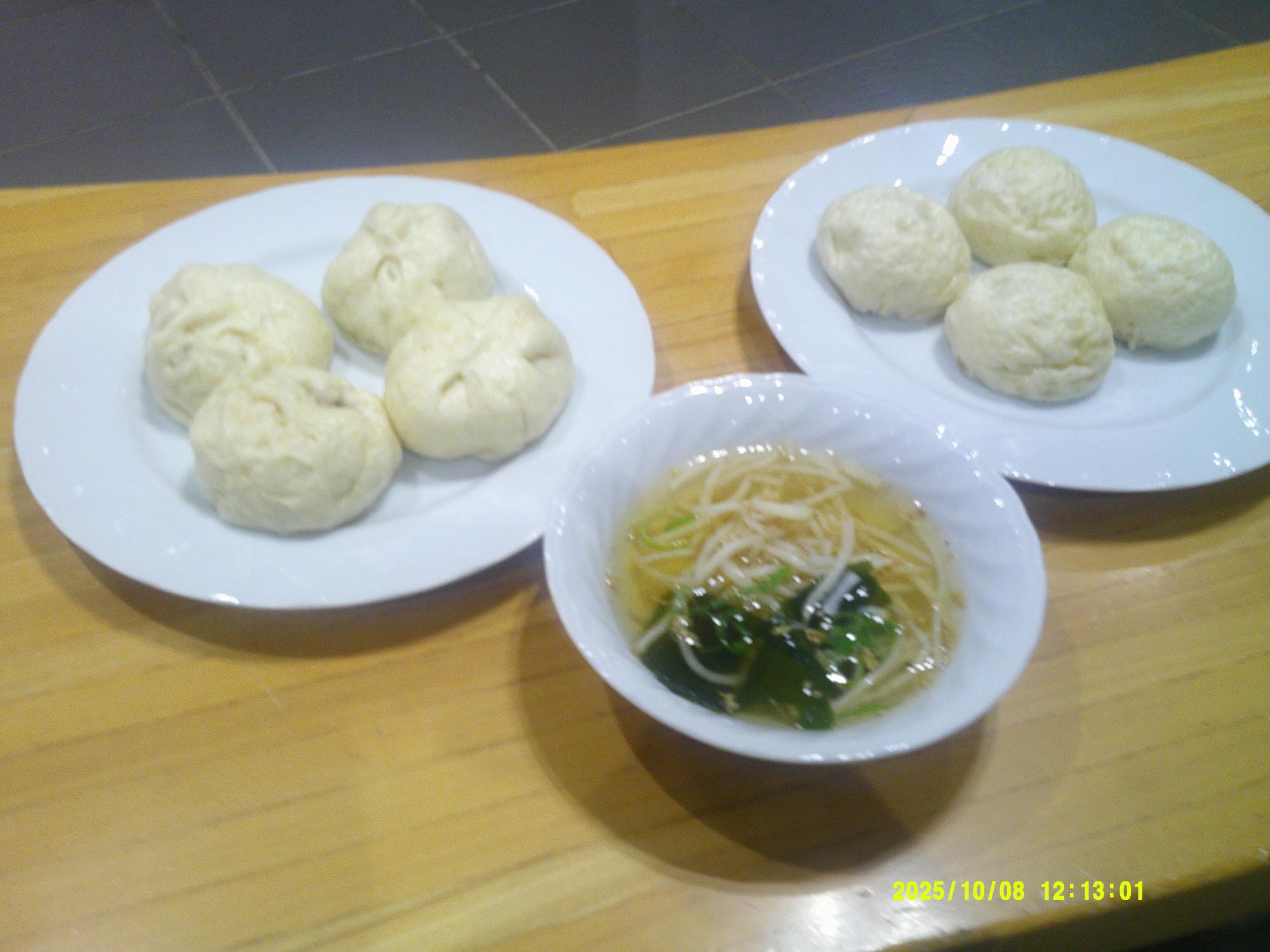 テーブルの上に、白い皿にそれぞれ四つずつ盛り付けられた肉まん・あんまんと、中華スープが置かれている写真