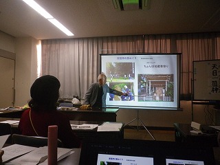 教室で行われているセミナーで、講師がスクリーンに写真を映し出し、参加者に向かって指差しながら解説をしている様子の写真