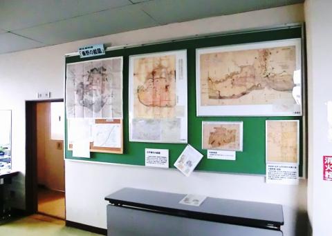 「秦野の絵図」と題された緑色の掲示板に、大小複数の絵図と解説が掲示されている様子の写真