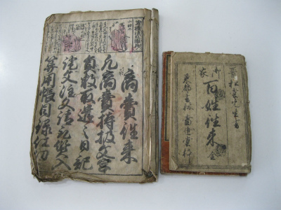 茶色く変色した紙に黒い文字で書かれた古い教科書が2冊並べられている写真