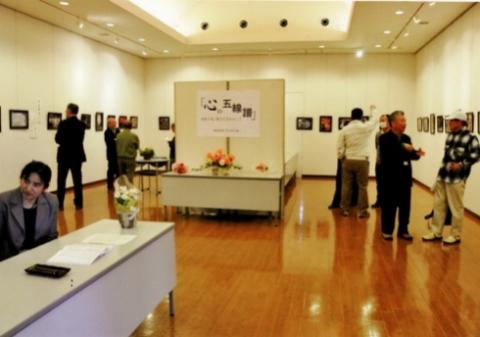 広々とした会場で、壁に飾られた作品を複数の来場者たちが鑑賞している写真