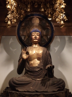 光背を背にした金色の体の木造阿弥陀如来坐像の写真