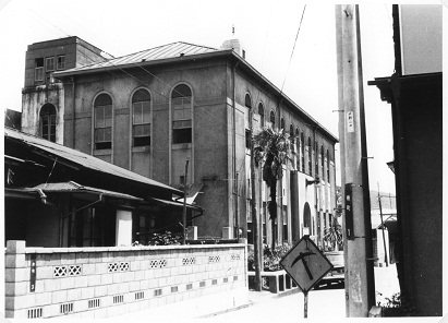 西洋風の建築様式で、丸いアーチ状の窓が並ぶ大きな秦野市役所旧庁舎が写った古いモノクロ写真