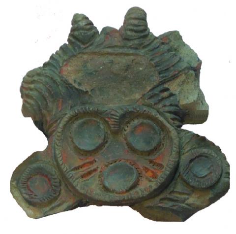 目のような模様と、口のような模様が描かれたミミズクを形どった土器の頭部の写真