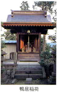 石の階段が付いた土台の上に、屋根がついた立派な祠が立っている写真の下に「鴨居稲荷」と書かれた画像
