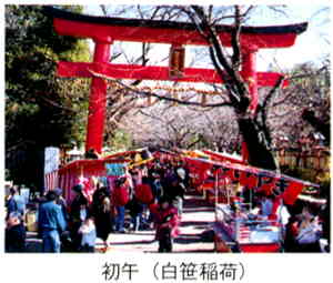 満開の桜並木を背景に、鮮やかな朱色の鳥居がある参道の両脇にたくさんの出店が並び、たくさんの人々で賑わっている写真の下に「初午（白笹稲荷）」と書かれた画像