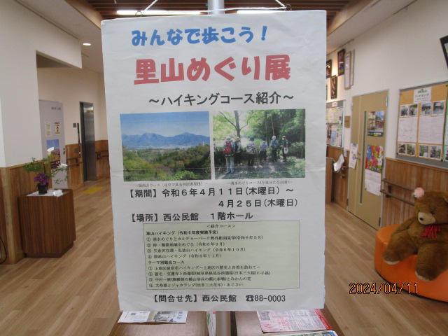 「みんなで歩こう！里山めぐり展」のポスターに、ハイキングコースの紹介や開催期間、場所、問い合わせ先などの詳細情報が記載されている、里山めぐり展の写真