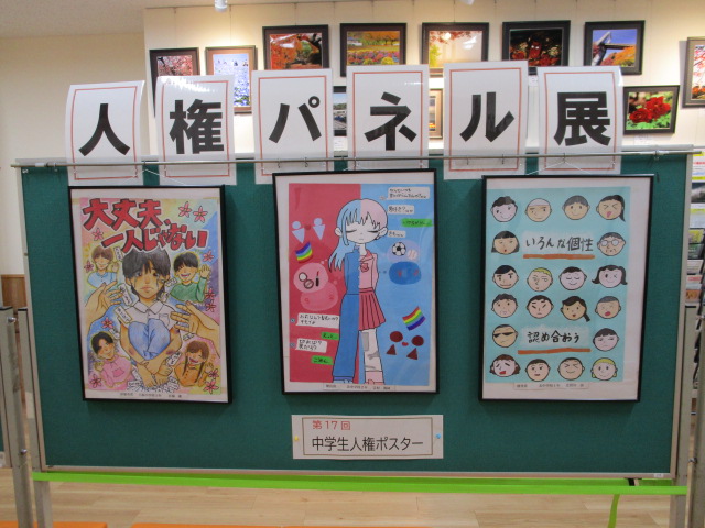 緑色の展示パネルの上部に「人権パネル展」と書かれた札が並び、その下には第17回中学生人権ポスターとして3枚の入賞作品が展示されている様子を捉えた写真