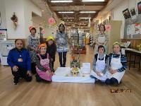 西公民館ロビーにて展示されたどんど焼きと女性交流会の皆さん