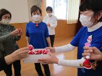 レクダンス講座の参加者に講師補助の方が手作りしたサンタクロースの帽子をプレゼントしている様子