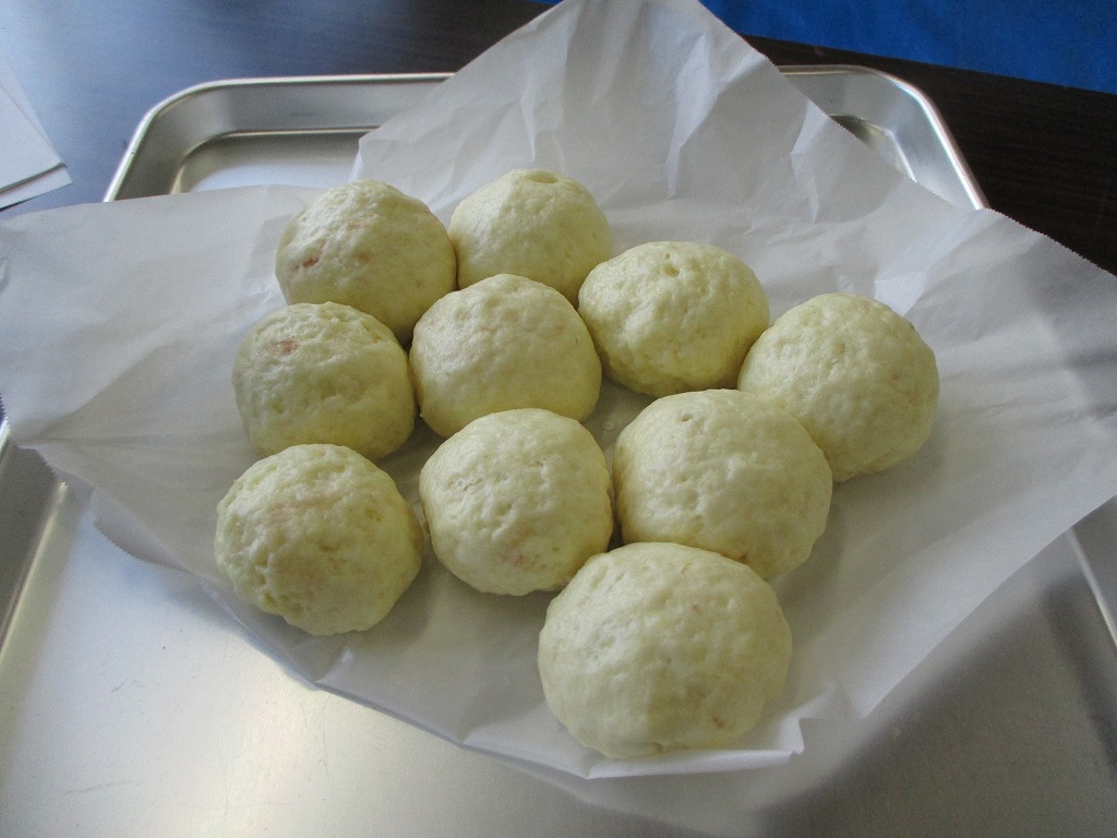 白いクッキングシートの上にきれいに並べられた、蒸しあがったばかりのふっくらとしたお月見まんじゅうの写真