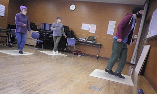 床のある一室で、参加者がそれぞれ白い板の上に立って、講師の指示に合わせてステップを踏んでいる様子の写真