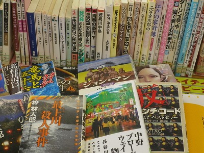 背表紙が見えるように並べられた本の手前に、推理小説やミステリー小説など様々なジャンルの表紙が見えるように平積みで展示されている、一般書の新着本コーナーの写真