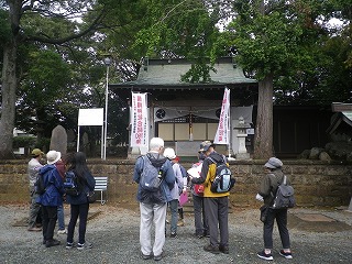 緑豊かな木々に囲まれた境内にある社殿の前に、リュックなどを背負った数人のグループが集まっている様子の写真