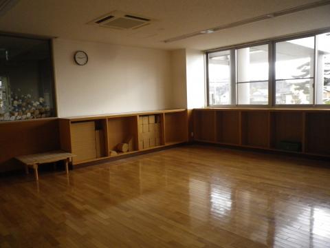 フローリングの室内に茶色の腰壁収納が設置された児童室の写真