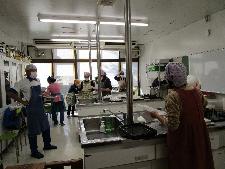 調理室で大人数名が講師の説明を聞いている