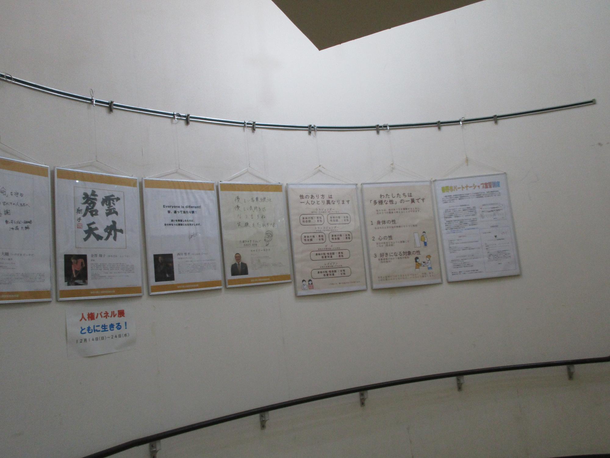 ワイヤーで吊られた人権パネルが数枚展示されている