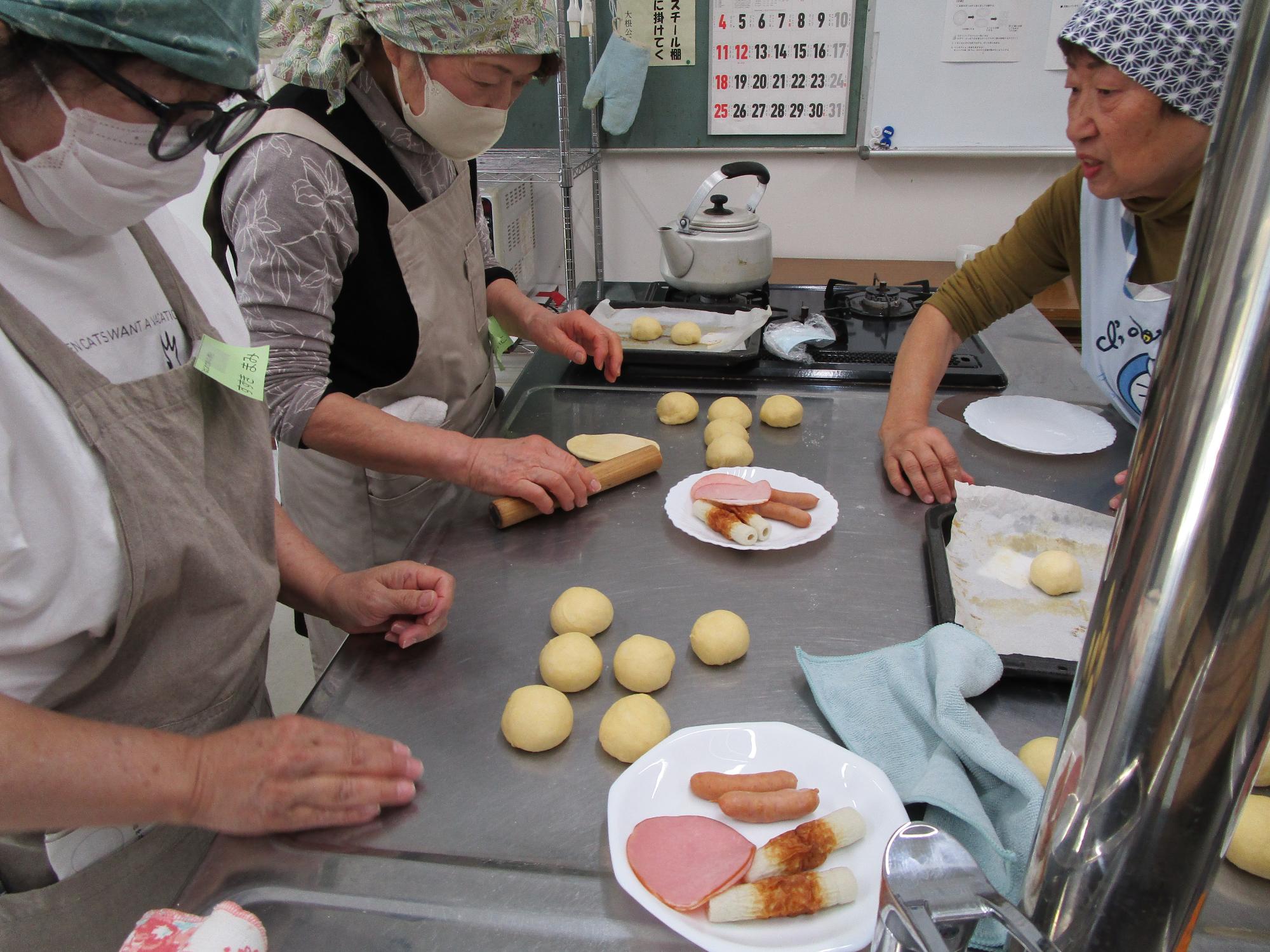 丸めたパン生地数個と、パンの中に入れる具材（ハム、ウィンナーソーセージ、ちくわ）がお皿に載っている。