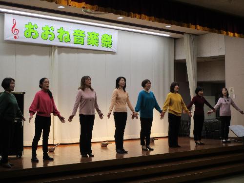 女性数名が手を広げてコーラスを披露している