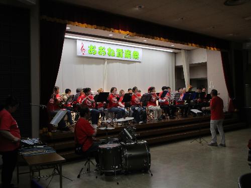 ステージ上で吹奏楽団が演奏している様子を観客席から撮影した写真