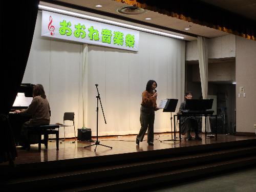 ステージ上で、女性3名がそれぞれピアノ、キーボード、歌を披露している