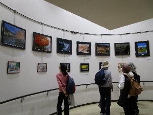 壁面に展示した写真を大人数人が見ている様子