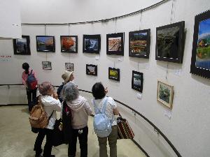 壁面に展示した写真を大人数人が見ている様子