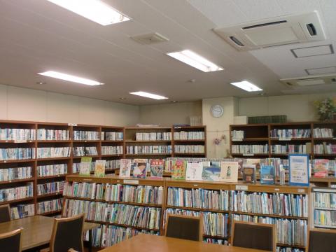 部屋いっぱいに並んだ書架に本がぎっしり入っている図書室の写真