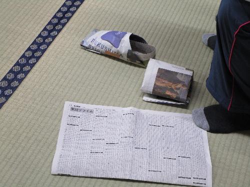 新聞紙と新聞紙で作った靴を映しています。